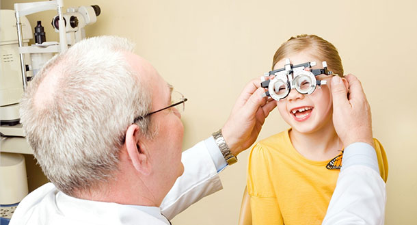 Optometrist treating myopia in a small, happy child.